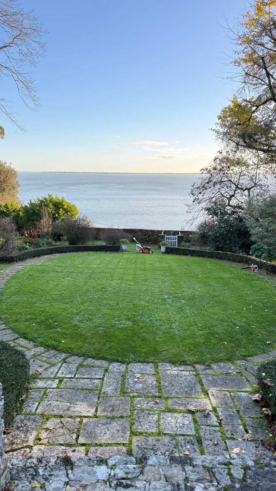 Pelouse tondue avec finitions des bordures dans un jardin donnant sur la mer